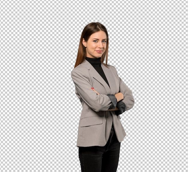 A professional young woman with long brown hair stands with her arms crossed, smiling at the camera. She's wearing a gray blazer over a black turtleneck.